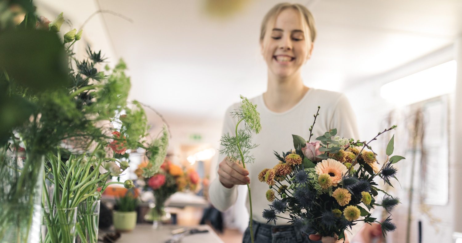 Elev står och plockar en bukett blommor