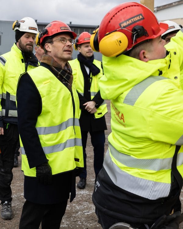 Statsministern kollar när byggeleverna arbetar.