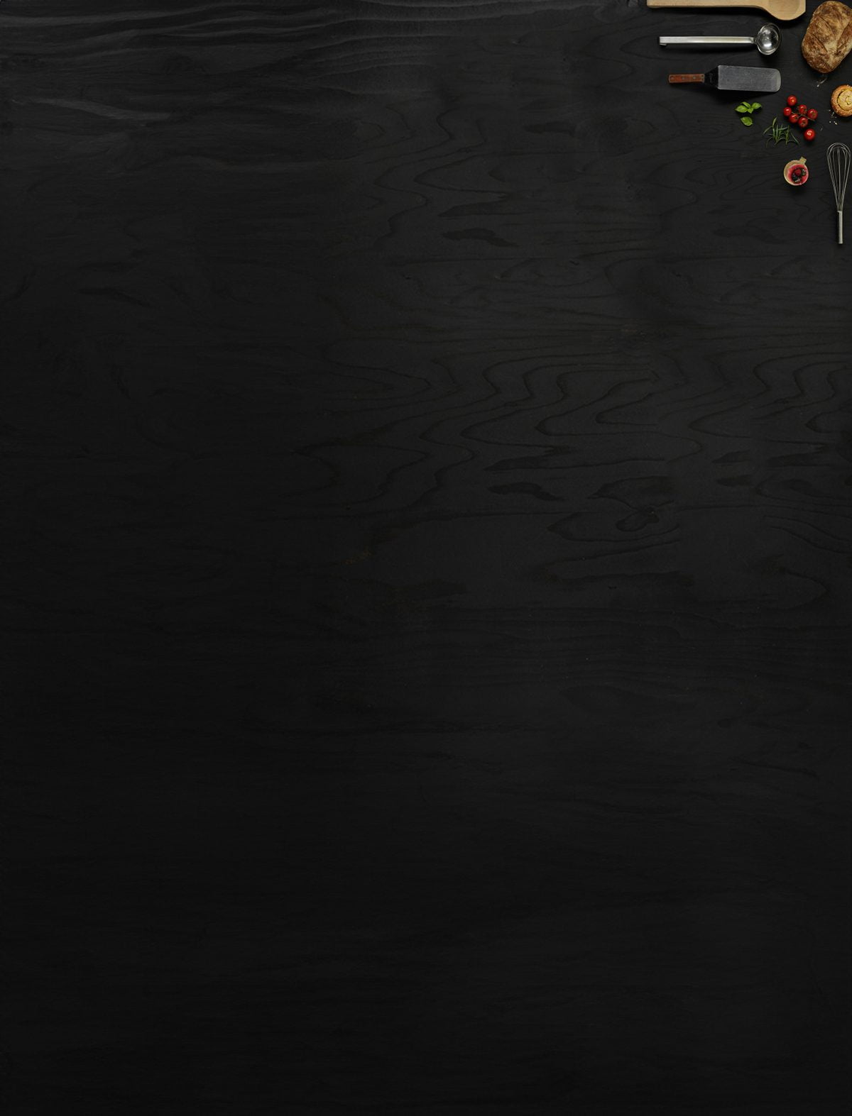 Föremål som representerar Restaurang- och livsmedelsprogrammet ligger utlagda på mörkt trä.