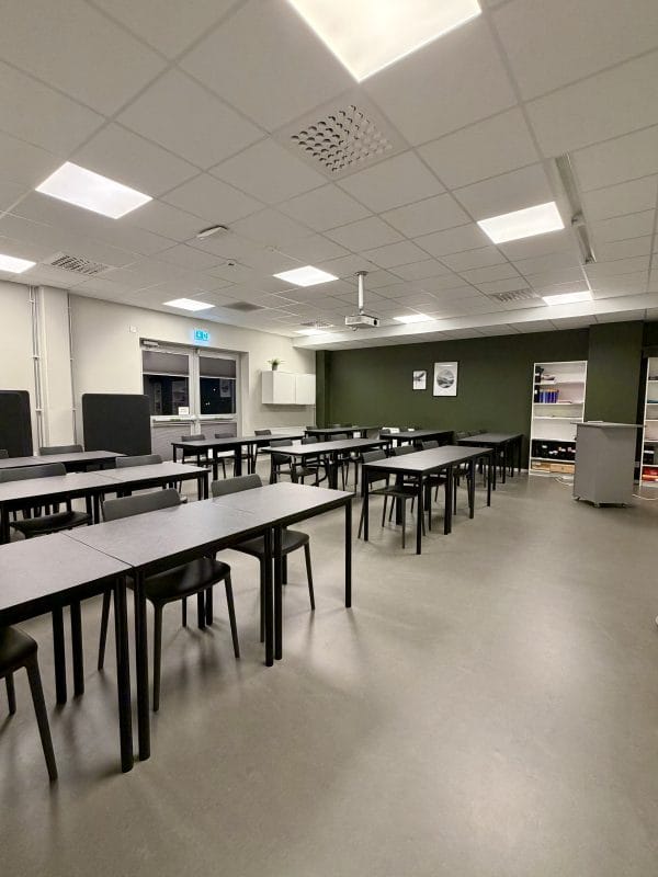 Ett klassrum med bord och stolar.