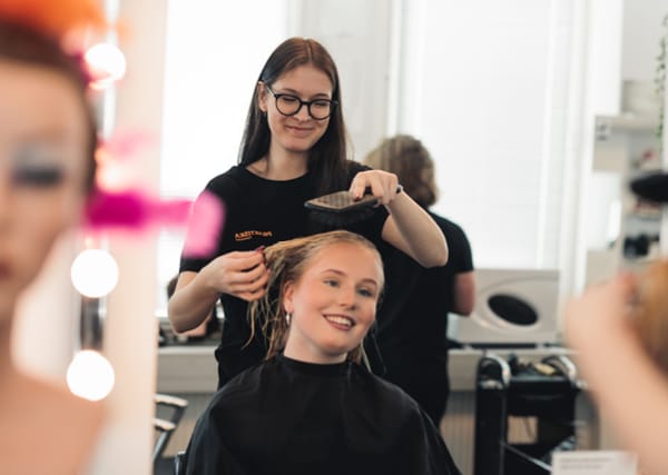 En elev borstar håret på en annan elev