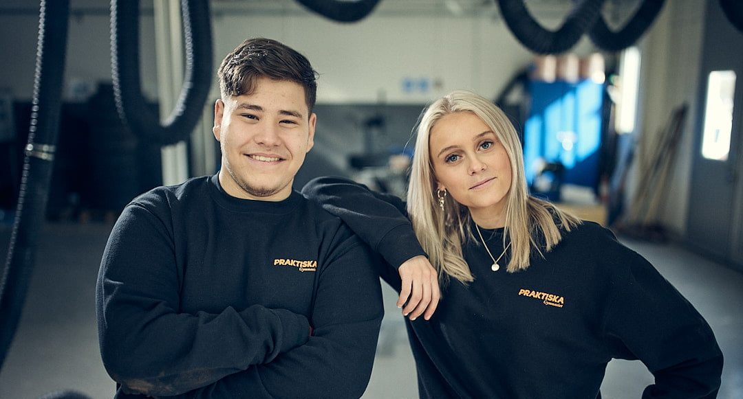 Två elever på Praktiska Gymnasiet som står i en verkstad