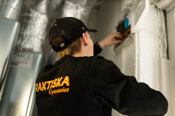 En elev på Praktiska som jobbar med ett elarbete på sin APL-plats.