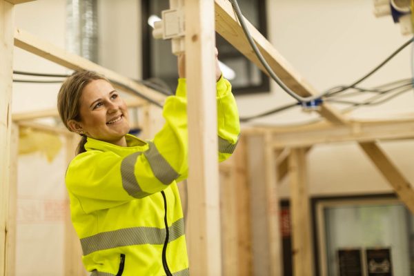 Elev på Praktiska Gymnasiet som drar el i en bygghall