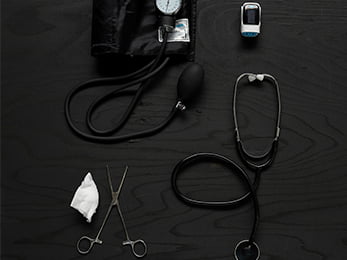 Föremål som representerar Vård- och omsorgsprogrammet ligger utlagda på mörkt trä.