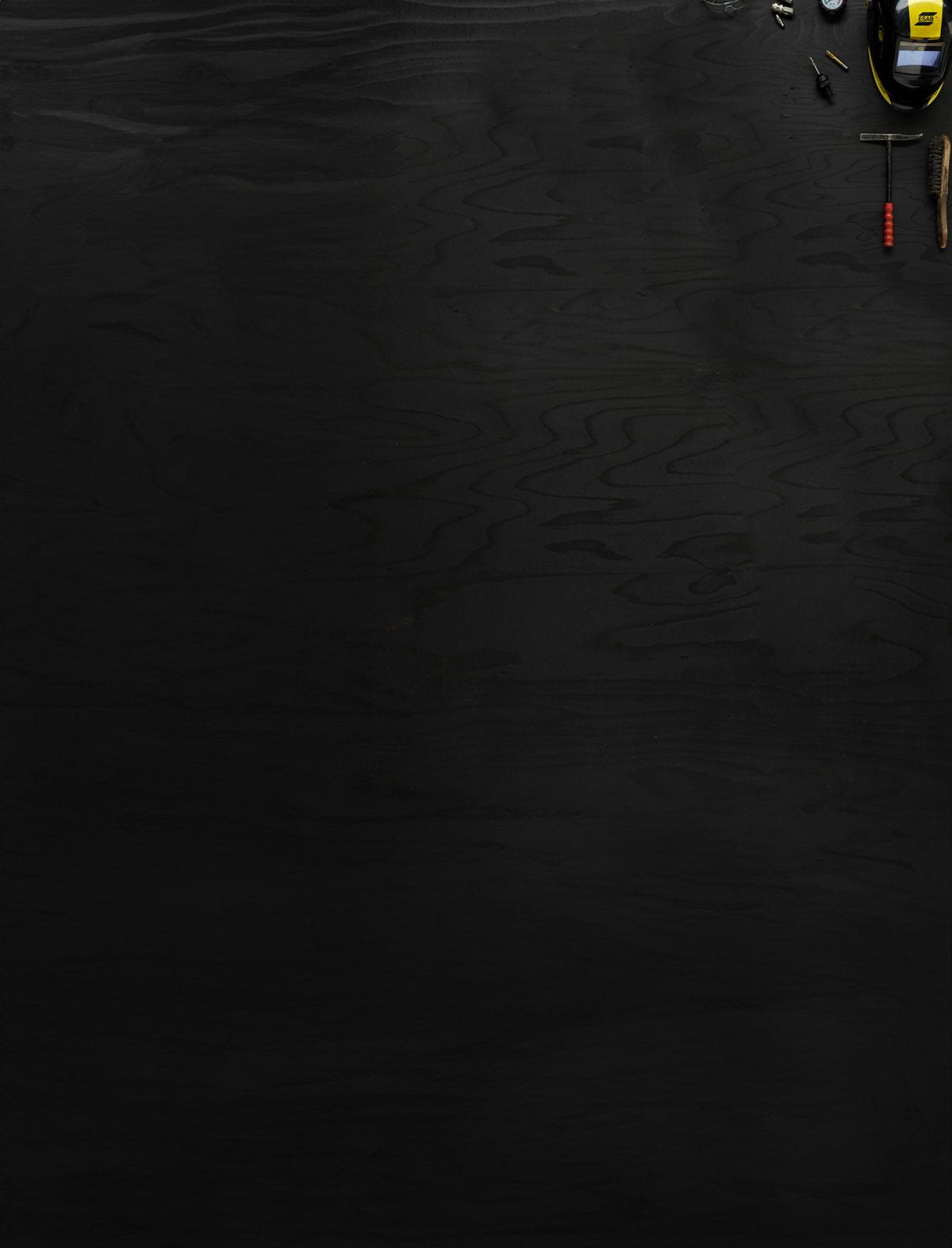 Föremål som representerar Industritekniska programmet ligger utlagda på mörkt trä.