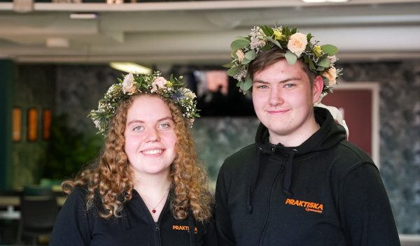 Porträttbild på två elever med blomkransar i håret