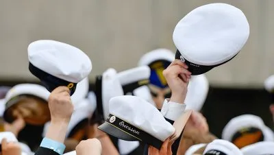 Studentmössor som hålls upp i luften.