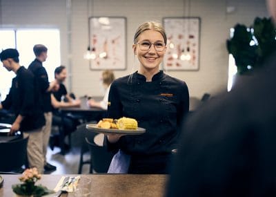 En restaurang där en elev ger mat till en besökare
