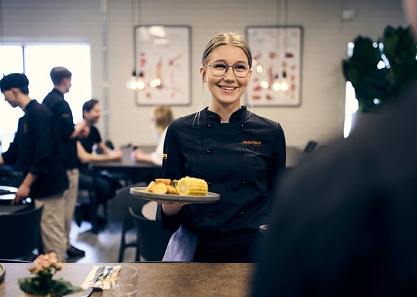 En restaurang där en elev ger mat till en besökare