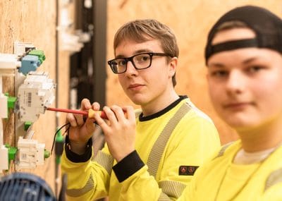Två elever som arbetar med el