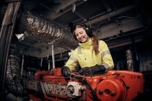 En elev står i maskinrummet och arbetar