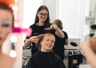 En elev borstar håret på en annan elev