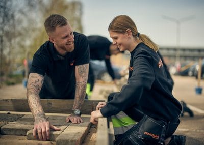 En lärare och en elev som hjälps åt på en byggarbetsplats