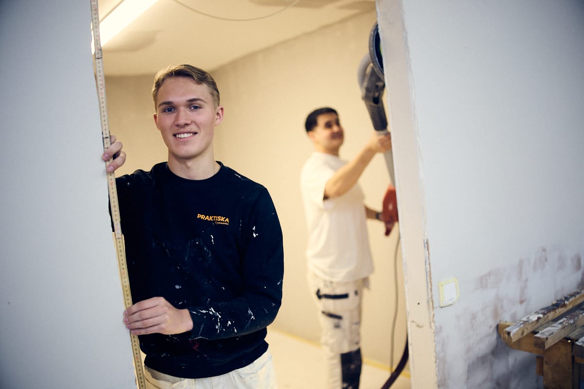 Två killar i ett målarrum.