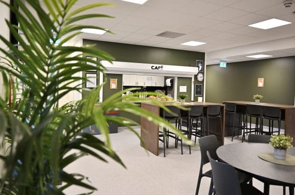 Skolcaféteria med bord och stolar.